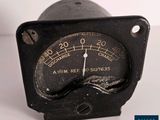 un gros plan d'un indicateur analogique noir sur une surface blanche