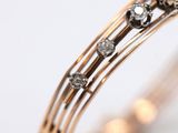 a close up of a gold bracelet with a pearl and diamonds