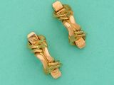 une paire de boucles d'oreilles à clip dorées sur fond turquoise