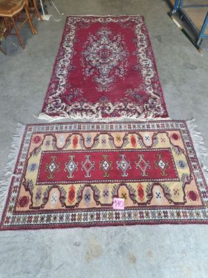 two rugs on the floor in a room with chairs and a table