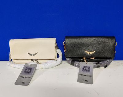 deux sacs à main noirs et blancs posés sur une table blanche