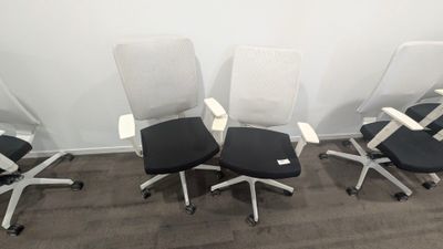 quatre chaises de bureau alignées dans une pièce vide