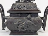a metal teapot with a lion on top of it