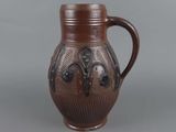 a brown vase with a handle on a gray background