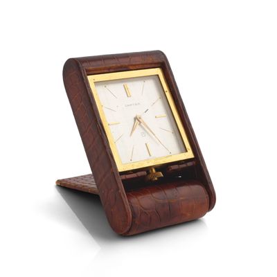 a wooden clock that is on a stand on a white surface