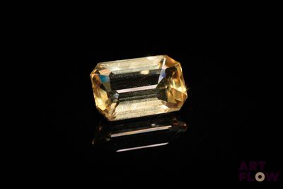 a yellow sapphire stone on a black surface