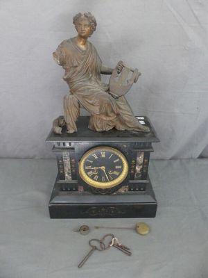 une statue de femme assise au sommet d'une horloge