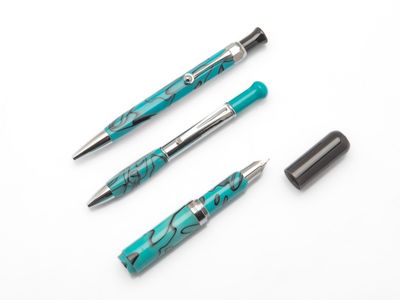 deux stylos et un stylo à bille roulante posés sur une surface blanche