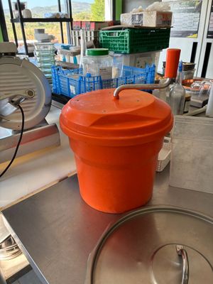 an orange bucket sitting on top of a metal counter