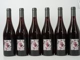 six bouteilles de vin sont alignées sur une table