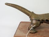 a bronze statue of a pheasant on a wooden block