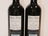 two bottles of red wine sitting on a table