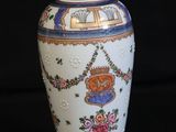 a white vase with a blue and red design on it
