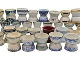 de nombreux vases de styles variés posés sur une surface blanche