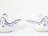 two white bowls with blue designs on them on a white surface