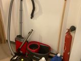 a picture of a room with a vacuum, a bucket, a mop, and other cleaning supplies
