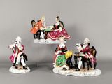 quatre figurines représentant des personnes vêtues de tenues élégantes, assises sur une table