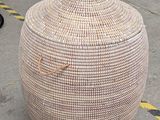 a large wicker basket with a lid sitting on the ground