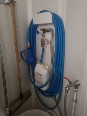un tuyau bleu fixé au mur à côté des toilettes