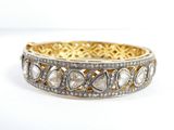 gros plan d'un bracelet en or et diamants sur fond blanc