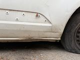 a white car that is parked on the side of the road