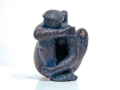 a small statue of a monkey sitting on a table