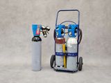 un petit chariot bleu chargé d'outils, à côté d'un vase