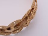 an image of a close up of a gold necklace on a white surface
