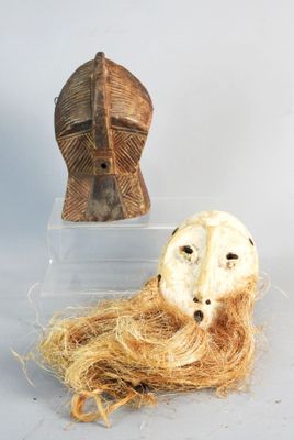 deux masques et un cheveu exposés dans une boîte transparente