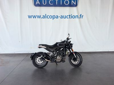 une moto noire garée devant un mur blanc
