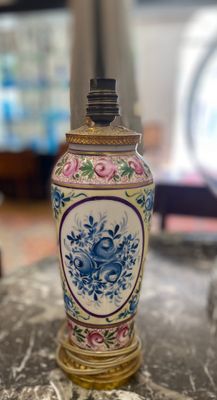 un vase posé sur une table, avec une horloge en arrière-plan