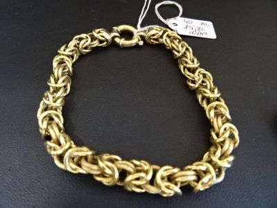 gros plan d'un bracelet en chaîne en or sur une table