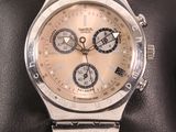 silver watch on a black cushion on a black surface