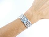 wrist of a woman with a watch on her wrist on a white background
