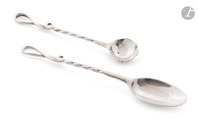 une paire de cuillères en argent posées sur une surface blanche, sur fond blanc