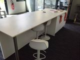 a long table with two stools in the middle of the room