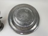 a silver plate sitting next to a metal bowl