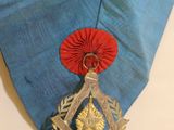 a medal on the neck of a man wearing a blue shirt
