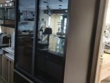 a refrigerator in the middle of a kitchen with a microwave on top of it
