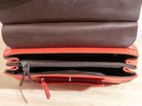a brown and orange purse that is open on the table