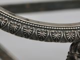 a close up of a silver plate on a stand