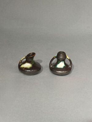 deux petits vases posés l'un à côté de l'autre sur une table
