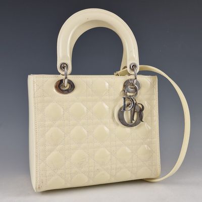 un sac à main blanc muni d'une poignée en métal et d'une chaîne