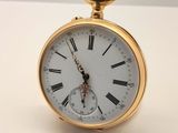une montre de poche en or avec des chiffres romains sur le cadran