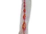 une brosse à dents orange et rose emballée dans du plastique sur un fond blanc