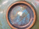 a close up of a blue vase with a brown rim