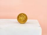 the gold coin is sitting on top of a marble block