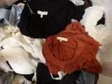 un tas de vêtements posé sur un lit, avec une étiquette dessus