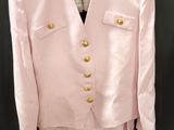 un costume rose avec des boutons dorés sur le devant