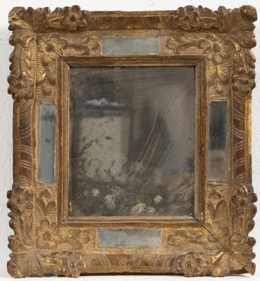 une image d'un miroir encadré d'or sur un mur blanc